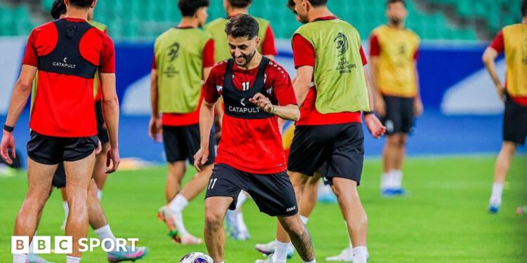 Iraq national team players warm-up on a football pitch