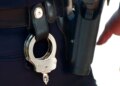 Handcuffs and gun on police belt