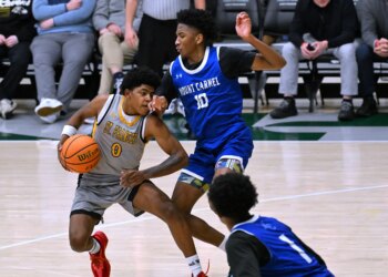 St. Frances' Terence Jones III is defended by Mount Carmel's...