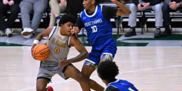 St. Frances' Terence Jones III is defended by Mount Carmel's...