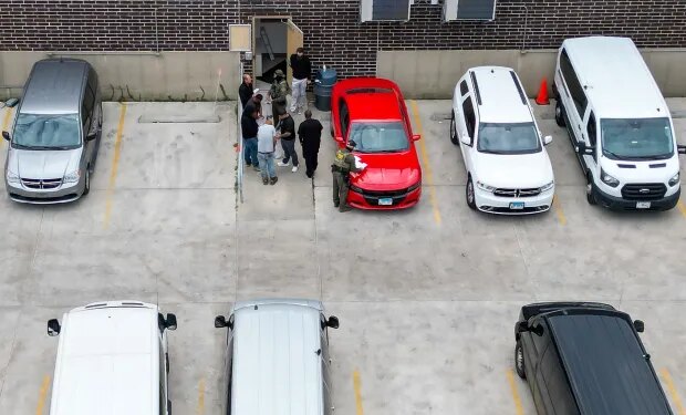 Detainees put items into clear plastic bags given to them by masked federal agents near an exterior door at the U.S. Immigration and Customs Enforcement holding facility in Broadview on Oct. 13, 2025. (Stacey Wescott/Chicago Tribune)