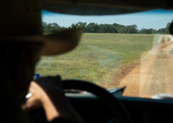 Bob Sanders steers his pickup along a dirt road on his East Texas ranch.