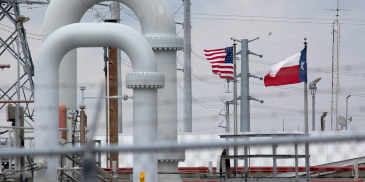 FILE PHOTO: FILE PHOTO: A maze of crude oil pipe and equipment is seen with the American and Texas flags flying during a t...