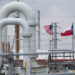 FILE PHOTO: FILE PHOTO: A maze of crude oil pipe and equipment is seen with the American and Texas flags flying during a t...