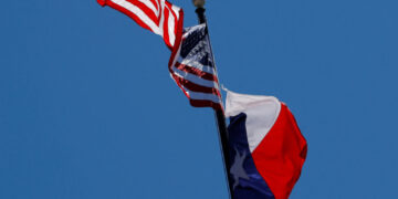 FILE PHOTO: The U.S flag and the Texas State flag fly over the Texas State Capitol in Austin