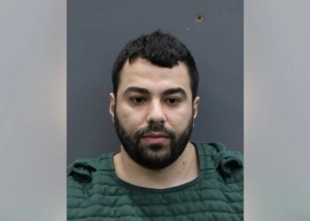 Hisham Abugharbieh in a booking photo facing forward against a height chart background