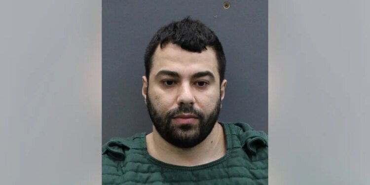 Hisham Abugharbieh in a booking photo facing forward against a height chart background