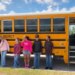 Mississippi middle school students stand next to a bus
