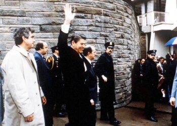 President Ronald Reagan waving to onlookers outside the Washington Hilton