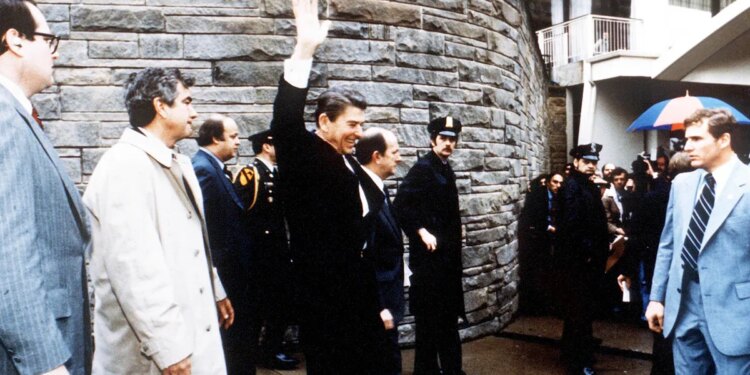 President Ronald Reagan waving to onlookers outside the Washington Hilton
