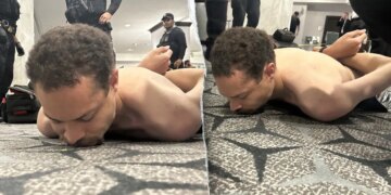 A suspect lying face down on the floor as law enforcement officers detain him