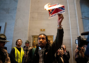 Democratic state representative Justin Jones walks out of the House Chamber and burns a photo of the Confederate Flag