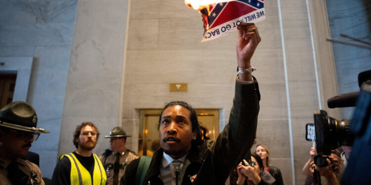 Democratic state representative Justin Jones walks out of the House Chamber and burns a photo of the Confederate Flag