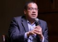 Minnesota Attorney General Keith Ellison speaking at a microphone indoors