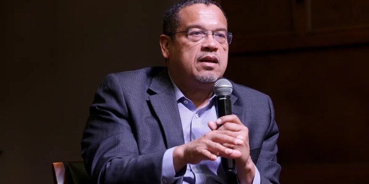 Minnesota Attorney General Keith Ellison speaking at a microphone indoors