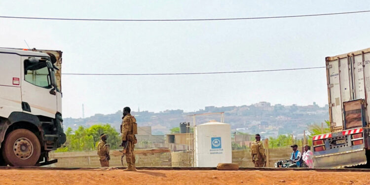 FILE PHOTO: Malian soldiers stand near a truck during a patrol following the attack on Mali's main military base Kati, out...