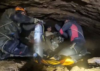 Rescue divers share the equipment usage guidelines with people trapped inside a cave during their rescue mission in Xaisom...