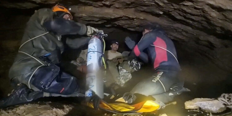 Rescue divers share the equipment usage guidelines with people trapped inside a cave during their rescue mission in Xaisom...