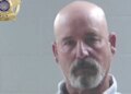 Mugshot of a bald goateed man