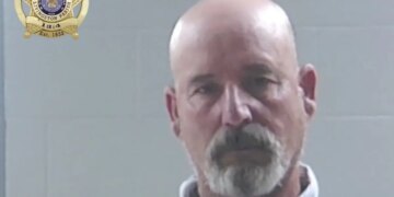Mugshot of a bald goateed man