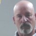 Mugshot of a bald goateed man