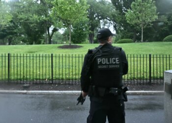 An armed Secret Service agent reacts at the White House