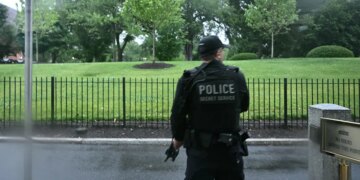 An armed Secret Service agent reacts at the White House