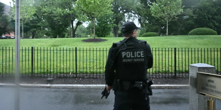An armed Secret Service agent reacts at the White House
