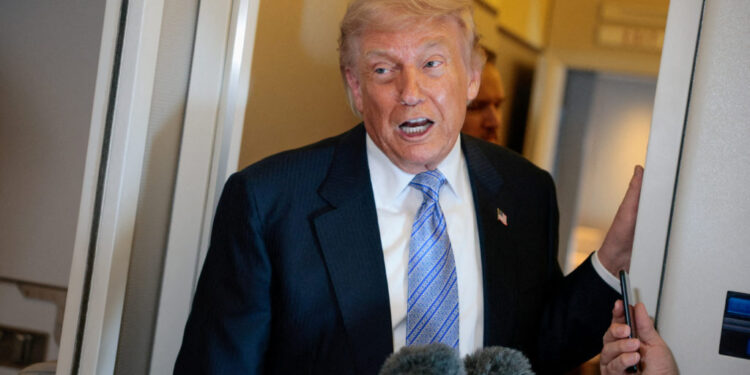 FILE PHOTO: U.S. President Donald Trump speaks to members of the media on board Air Force One, following his visit to China