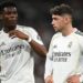 Real Madrid's Aurelien Tchouameni and Federico Valverde stand next to each other in a match, wearing the club's white kit