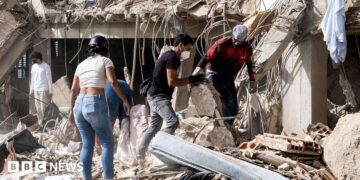 Family members and volunteers search through the rubble after two 17-story buildings in the Belo Horizonte residential complex collapsed in Catia La Mar, La Guaira (Venezuela), on June 26, 2026.