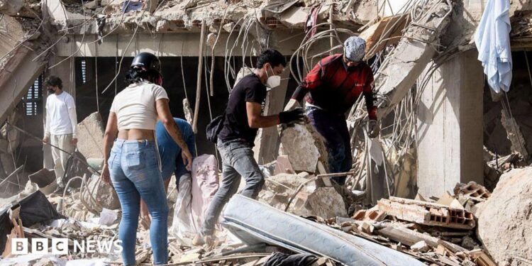 Family members and volunteers search through the rubble after two 17-story buildings in the Belo Horizonte residential complex collapsed in Catia La Mar, La Guaira (Venezuela), on June 26, 2026.