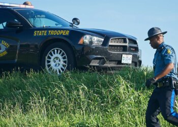 trooper near car on highway shoulder
