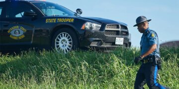trooper near car on highway shoulder