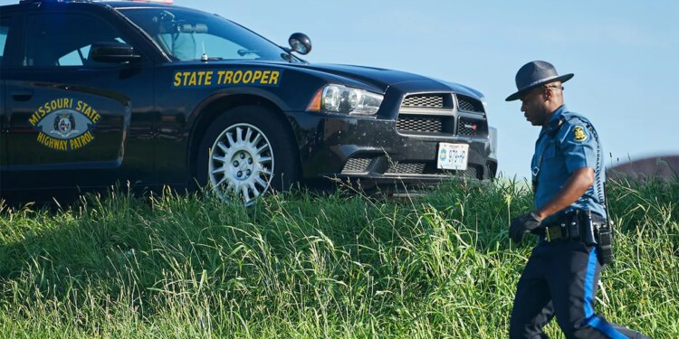 trooper near car on highway shoulder