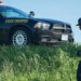 trooper near car on highway shoulder
