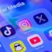 The app symbols for Snapchat, YouTube, Facebook, TikTok, Instagram and X are displayed on a smartphone screen, under the label Social Media.