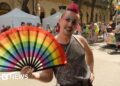 Man holds a pride fan