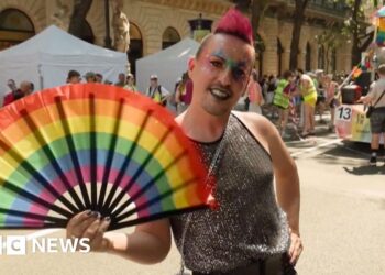 Man holds a pride fan