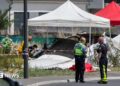 Emergency service workers speak to each other as the attend a light aircraft crash site