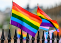 Rainbow flags sit atop a gate