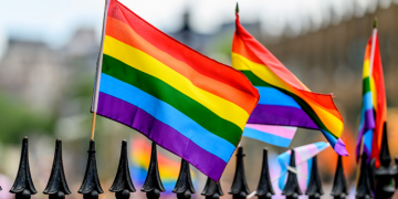 Rainbow flags sit atop a gate