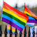 Rainbow flags sit atop a gate