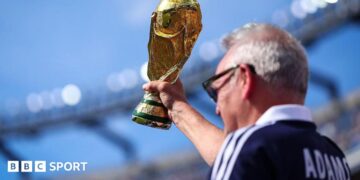 A Scotland supporter raises a replica FIFA World Cup Trophy in the stands prior to during the Group C match against Morocco
