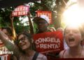 Tenant rights group members celebrating and cheering with sunshine and trees in the background in East Harlem, New York City.