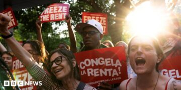 Tenant rights group members celebrating and cheering with sunshine and trees in the background in East Harlem, New York City.