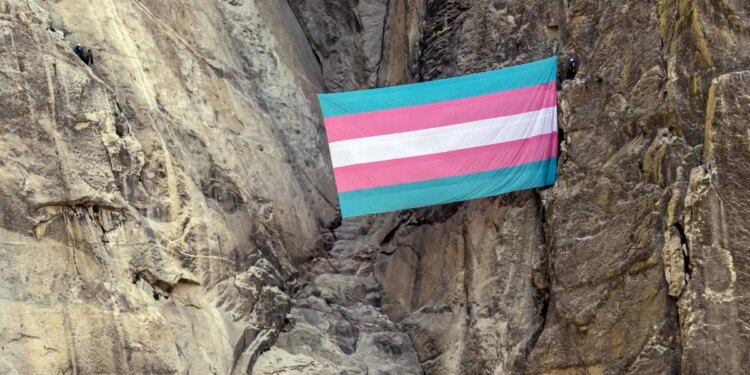 A group of transgender queer allied climbers unfurl a trans pride flag on El Capitan in Yosemite National Park