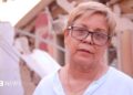 Zuly Marín, dressed in a white shirt and black glasses, stares into space.