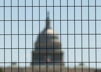 Dome of the U.S. Capitol seen through construction fencing as preparations for Freedom 250 continue along the National Mal...