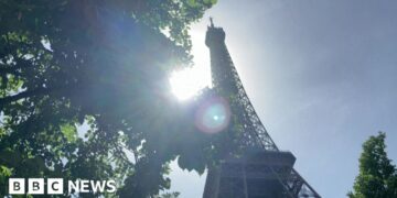 The Sun shining behind the Eiffel Tower